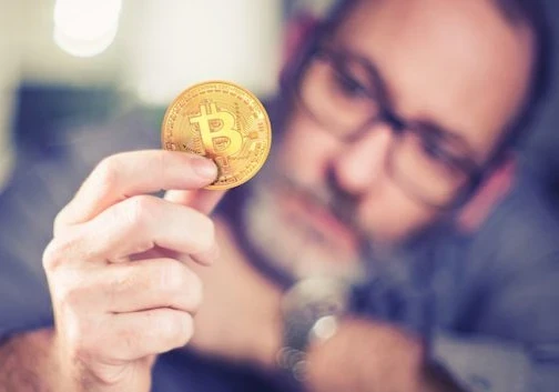 Image showing someone holding a gold Bitcoin coin