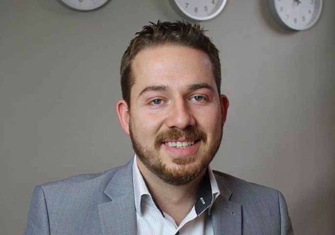 Profile picture of Rob Smith in a gray suit against a beige background.