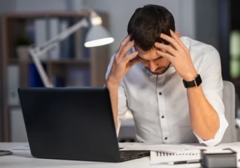 A frustrated man sitting at a computer