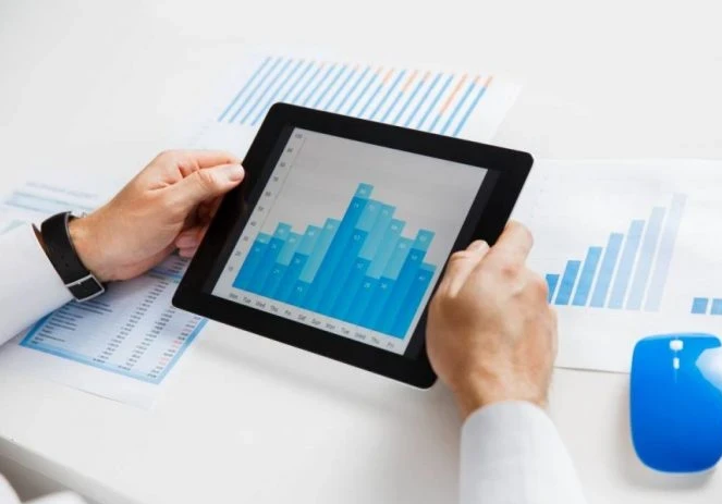 person holding a tablet with a graph
