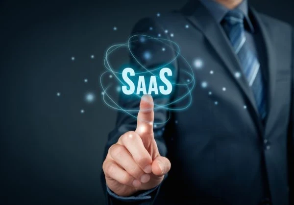 Person pointing to a sign that reads SaaS