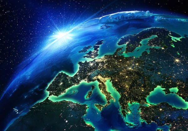Image of the world with the rising sun in the background and the focus on Europe lighting up