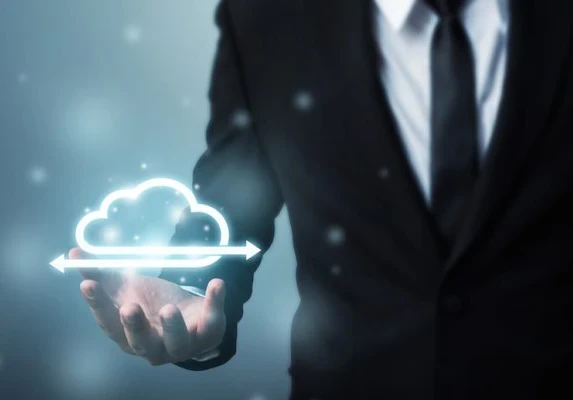 Man in a suit holding up a virtual depiction of cloud management.