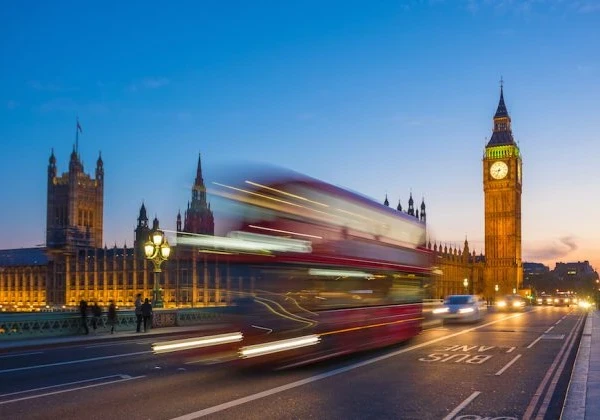 Image of London's Big Ben with a London red bus zooming past