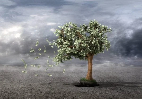 Image of a desert with a tree with dollar bills for leaves blowing away in the wind