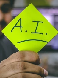 Person holding up a highlighter yellow paper with the words "A.I." on it.