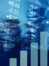 An image depicting a graph, coins and stocks.
