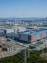Aerial view of a large South Korean semiconductor manufacturing complex, with the headline “South Korea Sets Record 2027 Budget as AI Chip Boom Lifts Tax Revenue.”