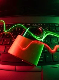 Image depicting a gold lock on a computer keyboard with streams of green and red neon light.