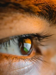 Indian flag on a computer screen reflecting in an Indian man's eye.