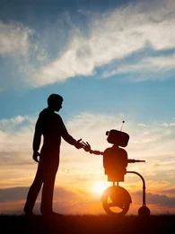 A person shaking hands with a robot with a sunset in the background.