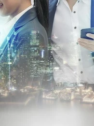 A cityscape of lit up skyscrapers projected onto female and male professionals