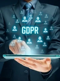 Businessman holding a tablet with the acronym "GDPR" floating above it.