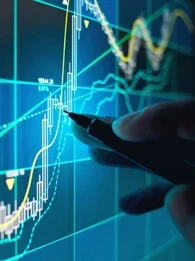 Hand using a pen to point at a graph on a screen.