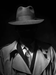 Mysterious spy lurking in the shadows in a trench coat.