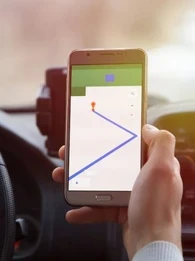 A person driving and using a smartphone map
