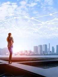 Person looking out across a river to a city skyline