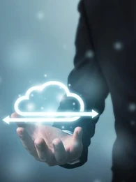 Man in a suit holding up a virtual depiction of cloud management.