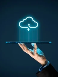 Hand holding up a tablet with a cloud icon floating above it.