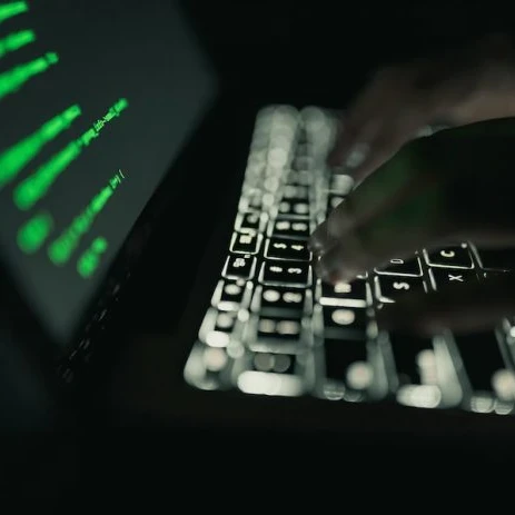 Hacker working on a laptop showing a data leak