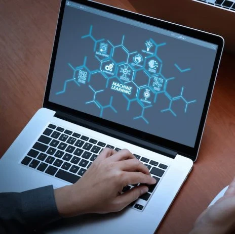 Someone working on a laptop with a mindmap with "machine learning" in the middle of the screen