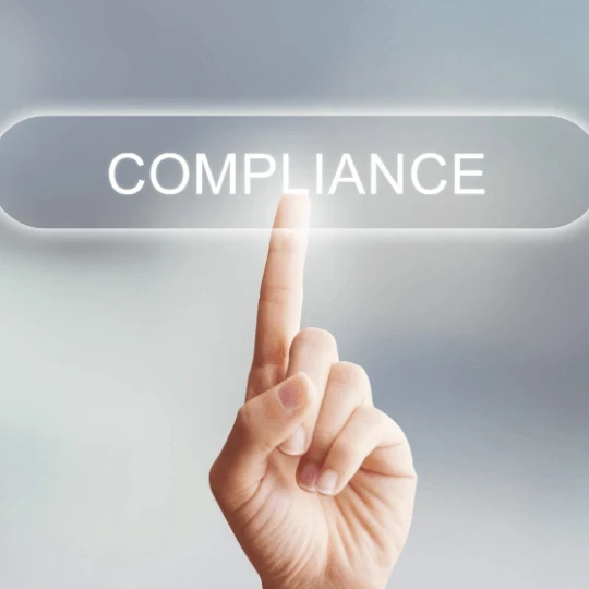 A hand pressing a button with the words "COMPLIANCE" on it.