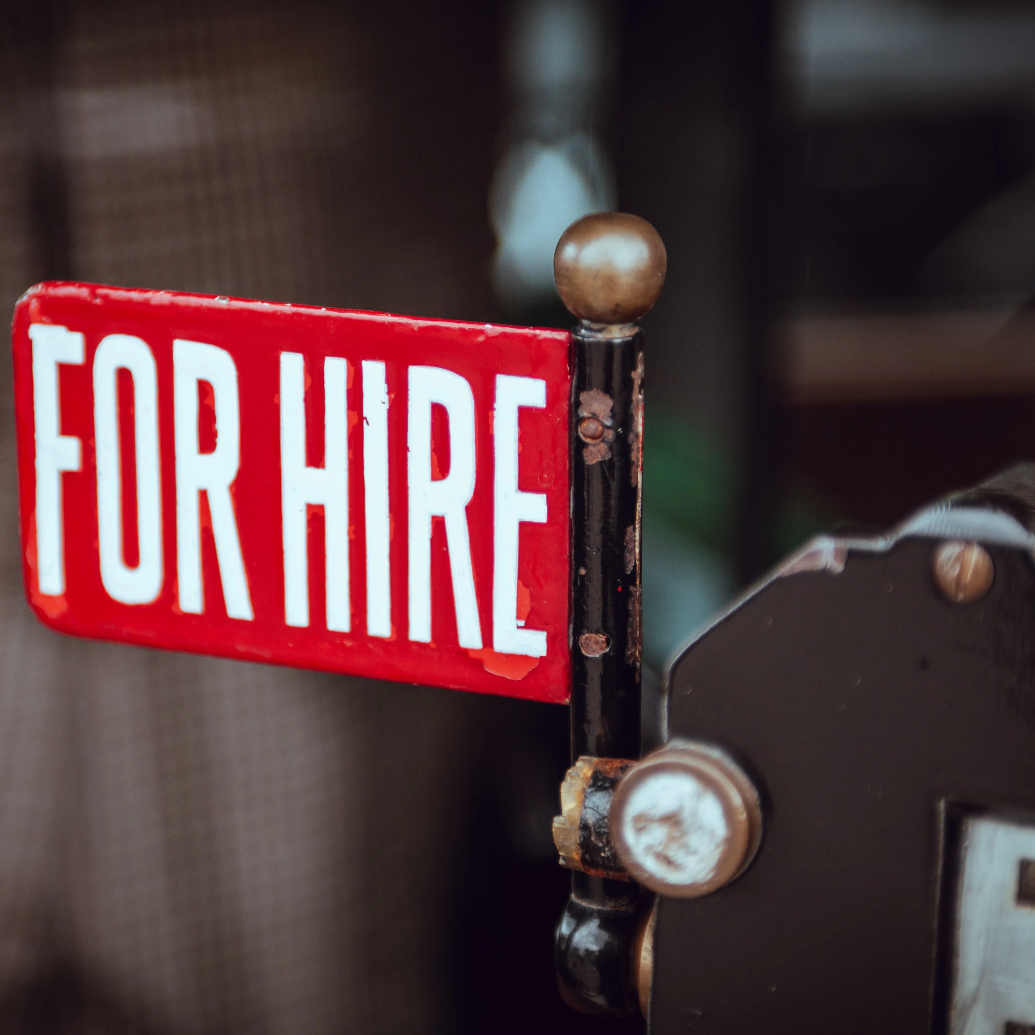 A close-up of a "for hire" sign on an old-fashioned machine.
