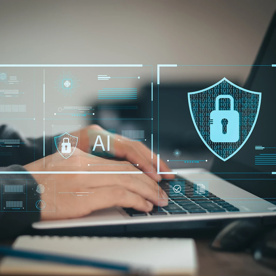 A businessman typing on a laptop with icons floating around it depicting online security.
