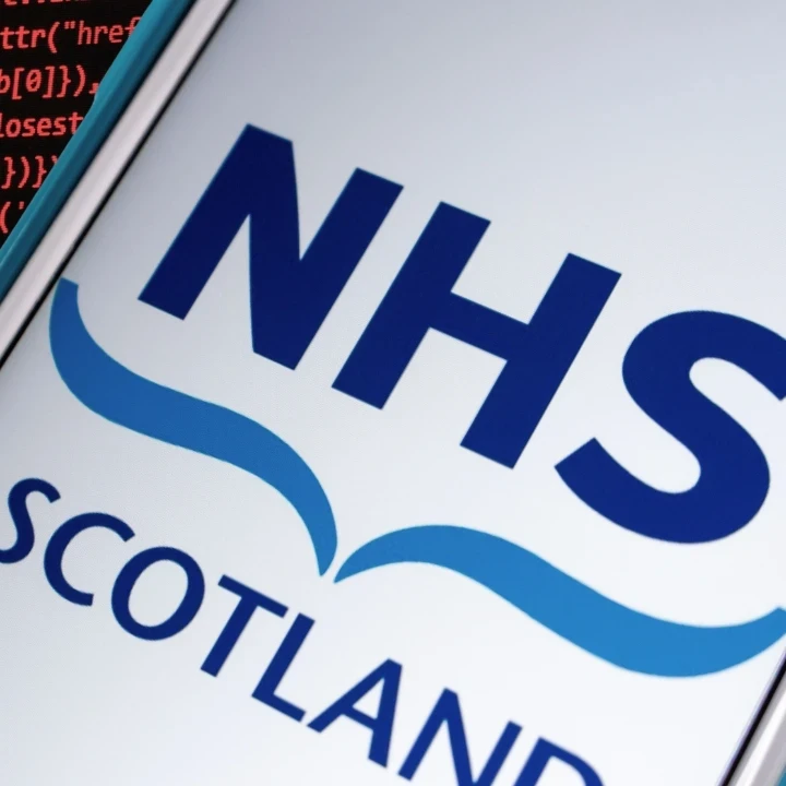 NHS Scotland logo on a smartphone with a coding background.