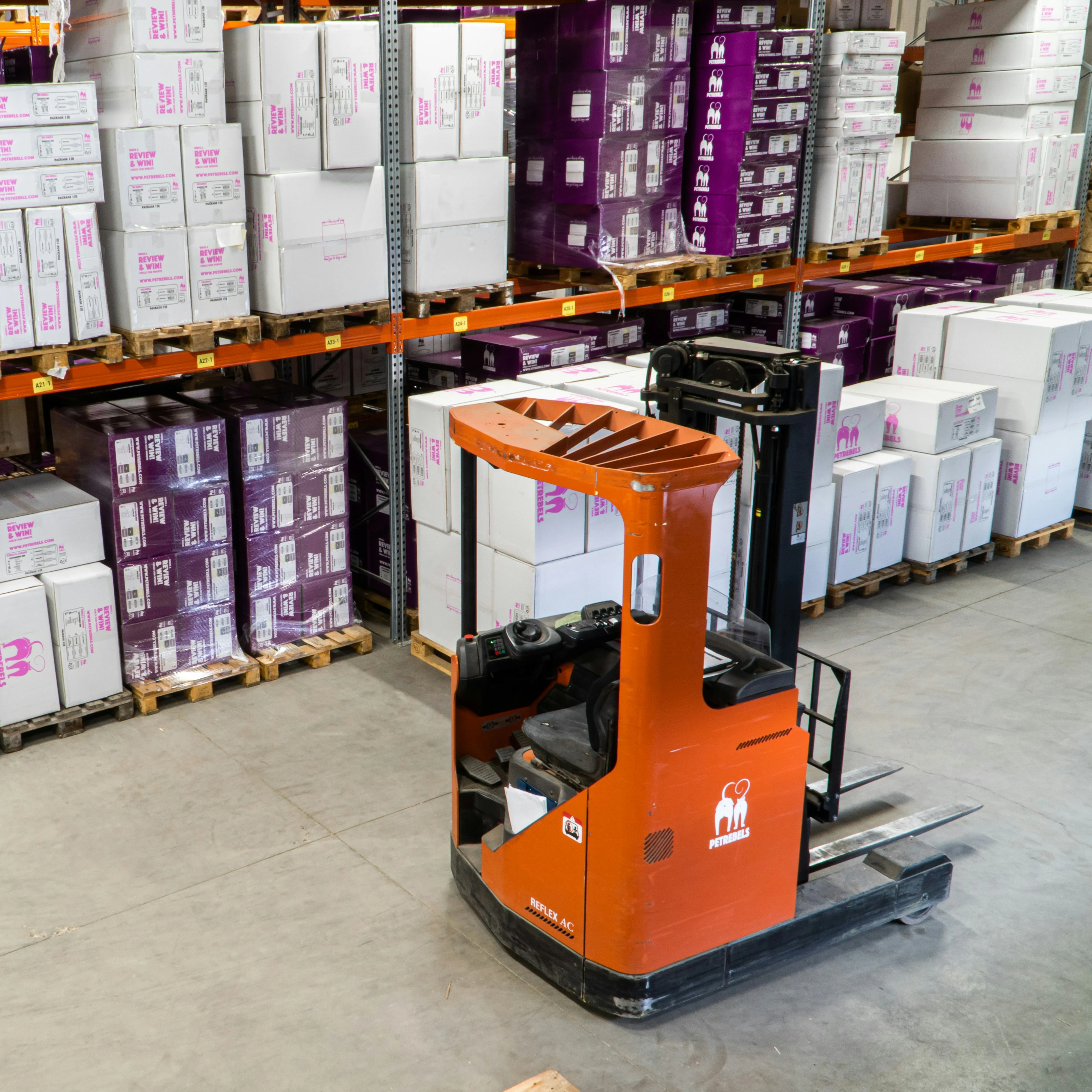 Inside of a warehouse with a forklift in front of a storage unit.