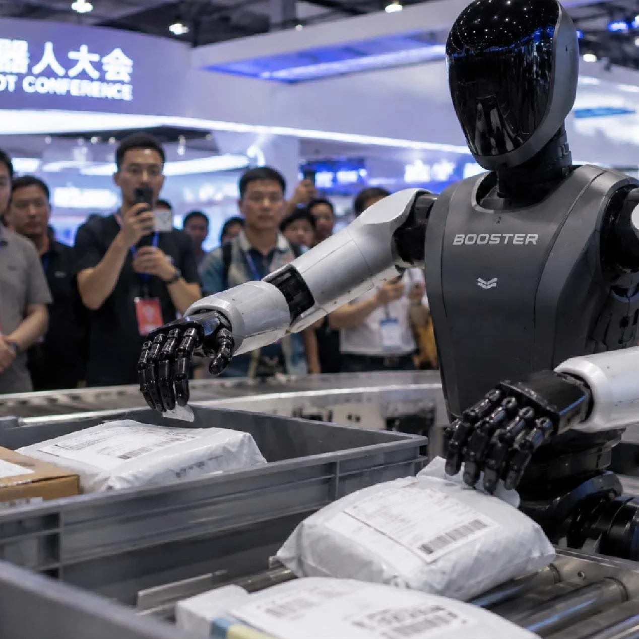 A humanoid Booster robot demonstrates parcel handling on a conveyor at the World Robot Conference as a crowd watches and records. Overlaid text reads: “EM360TECH China’s Humanoid Robots Are Leaving The Demo Stage, But Their Brains Are Still Catching Up.”