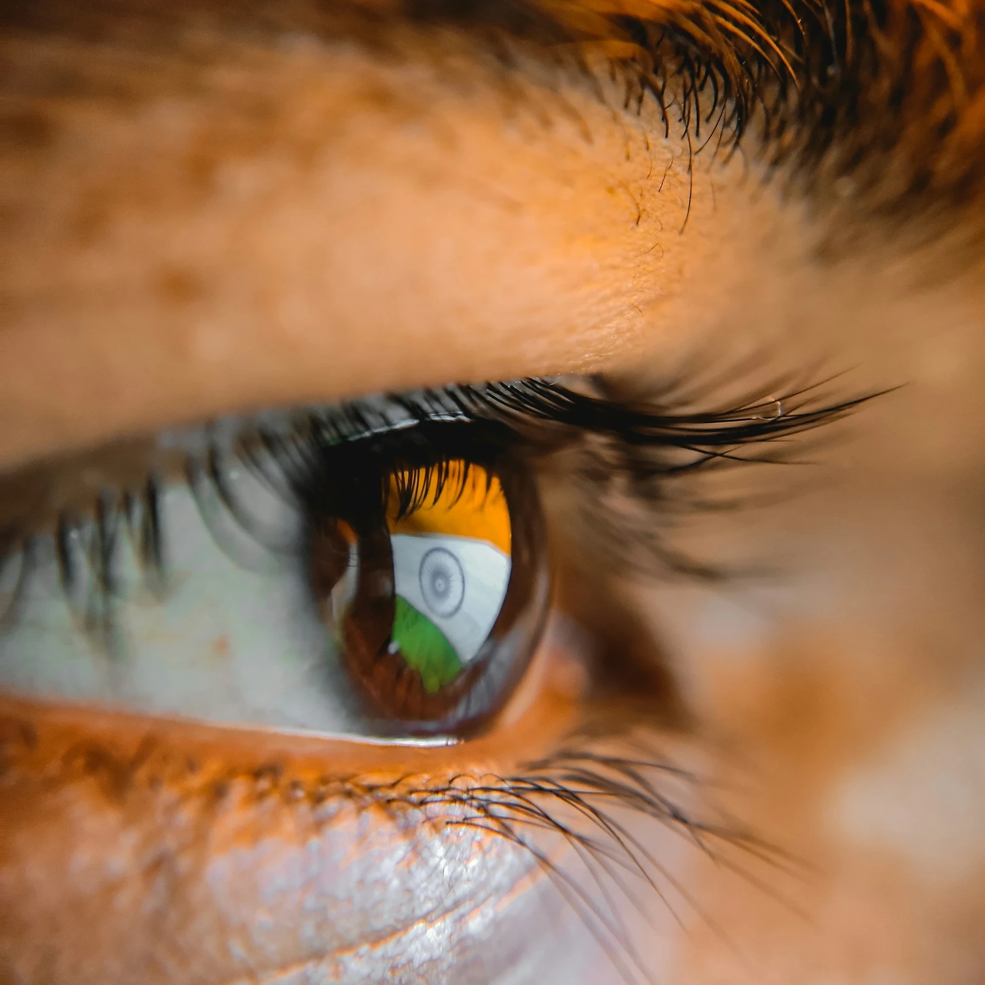 Indian flag on a computer screen reflecting in an Indian man's eye.