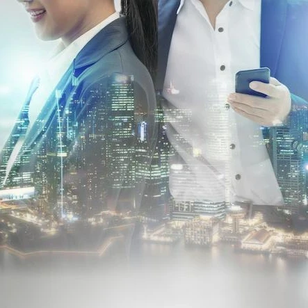 A cityscape of lit up skyscrapers projected onto female and male professionals