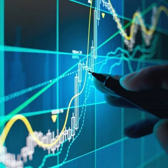 Hand using a pen to point at a graph on a screen.