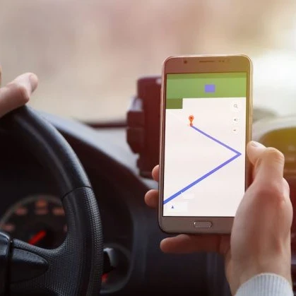 A person driving and using a smartphone map