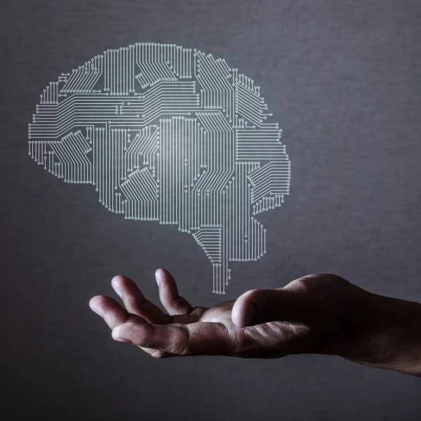 Decorative image of brain in computer chip styloating above hand