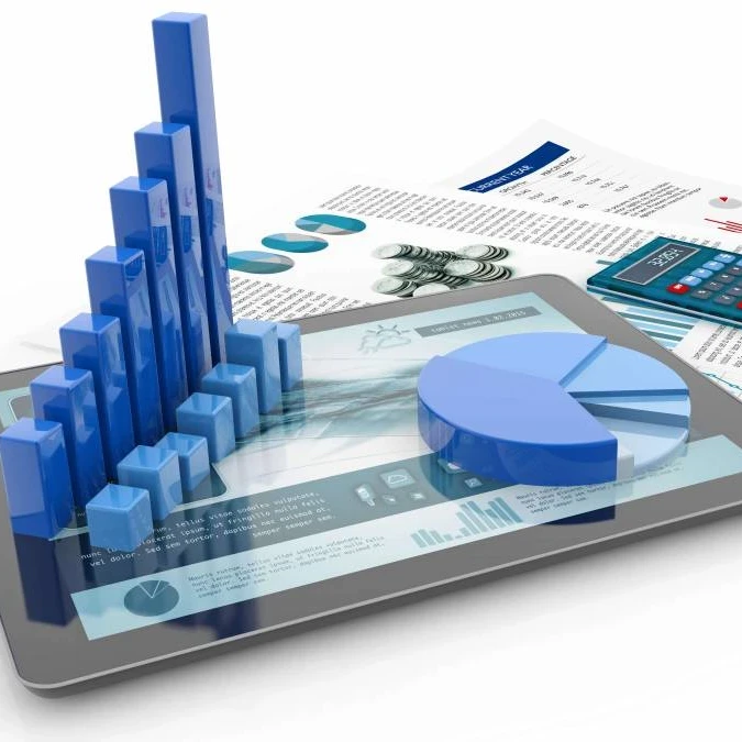 A smartphone and calculator lying on top of a desk with animated depictions of graphs.
