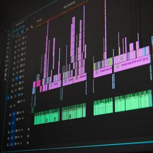 Audio editing software displaying multiple coloured waveform tracks on a dark interface.