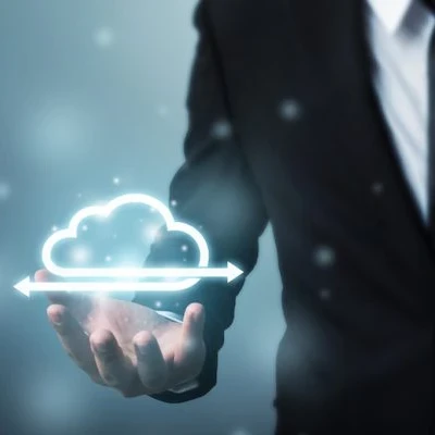 Man in a suit holding up a virtual depiction of cloud management.