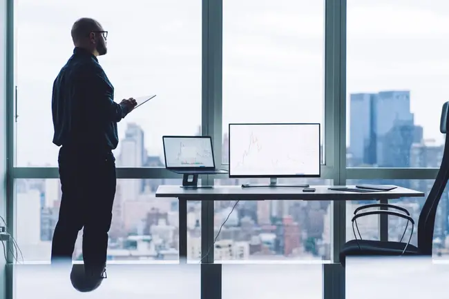 Business professional staring out the window while thinking